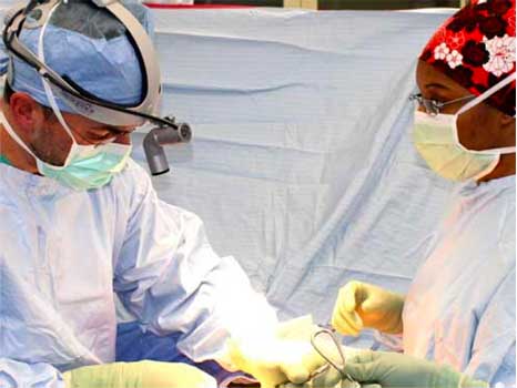 Surgeon and nurse performing a procedure
